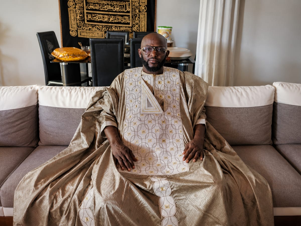 Marabout Djibril in a golden boubou, seated in his living room